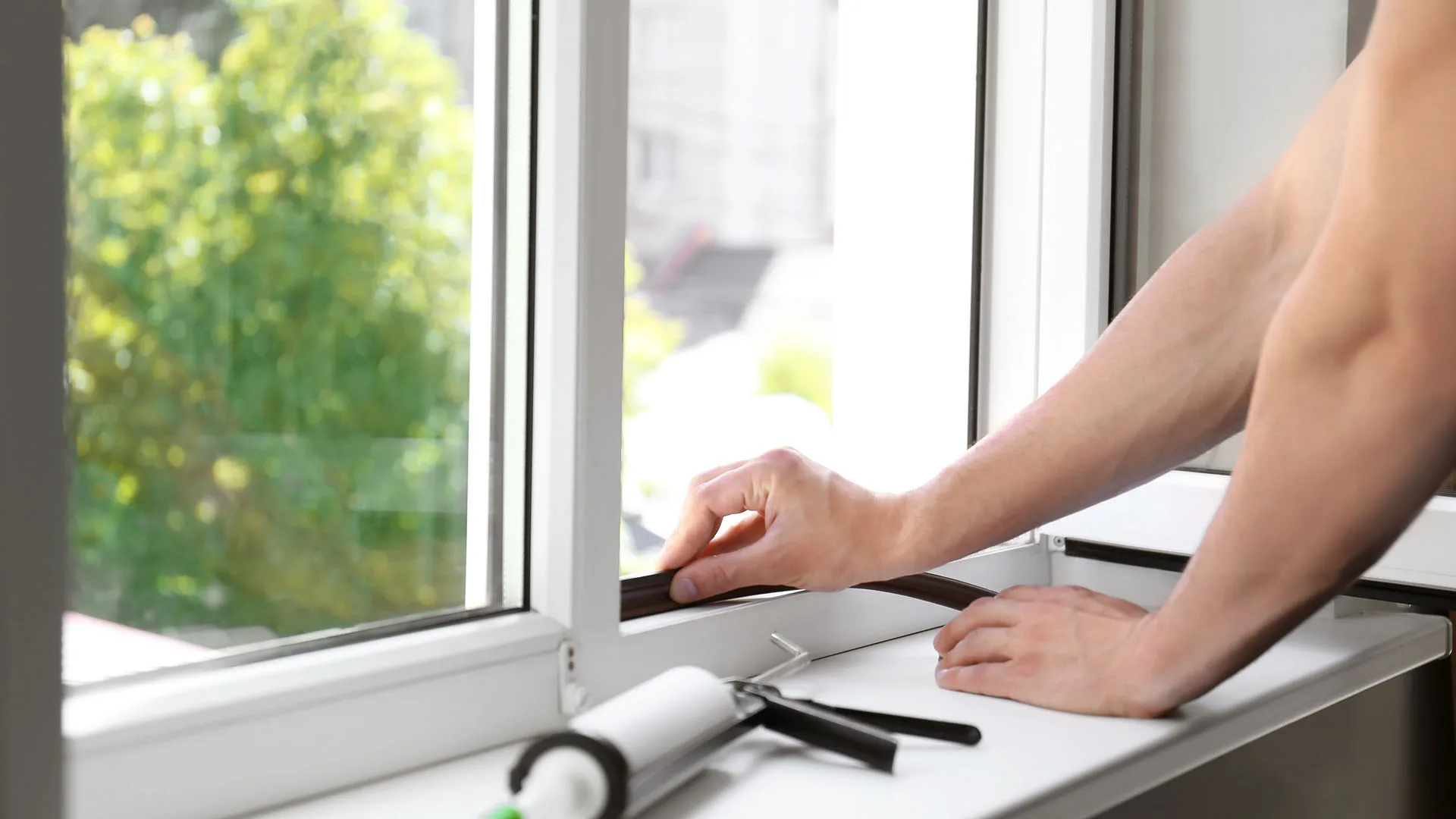 Construction professional applying sealant around a residential window frame